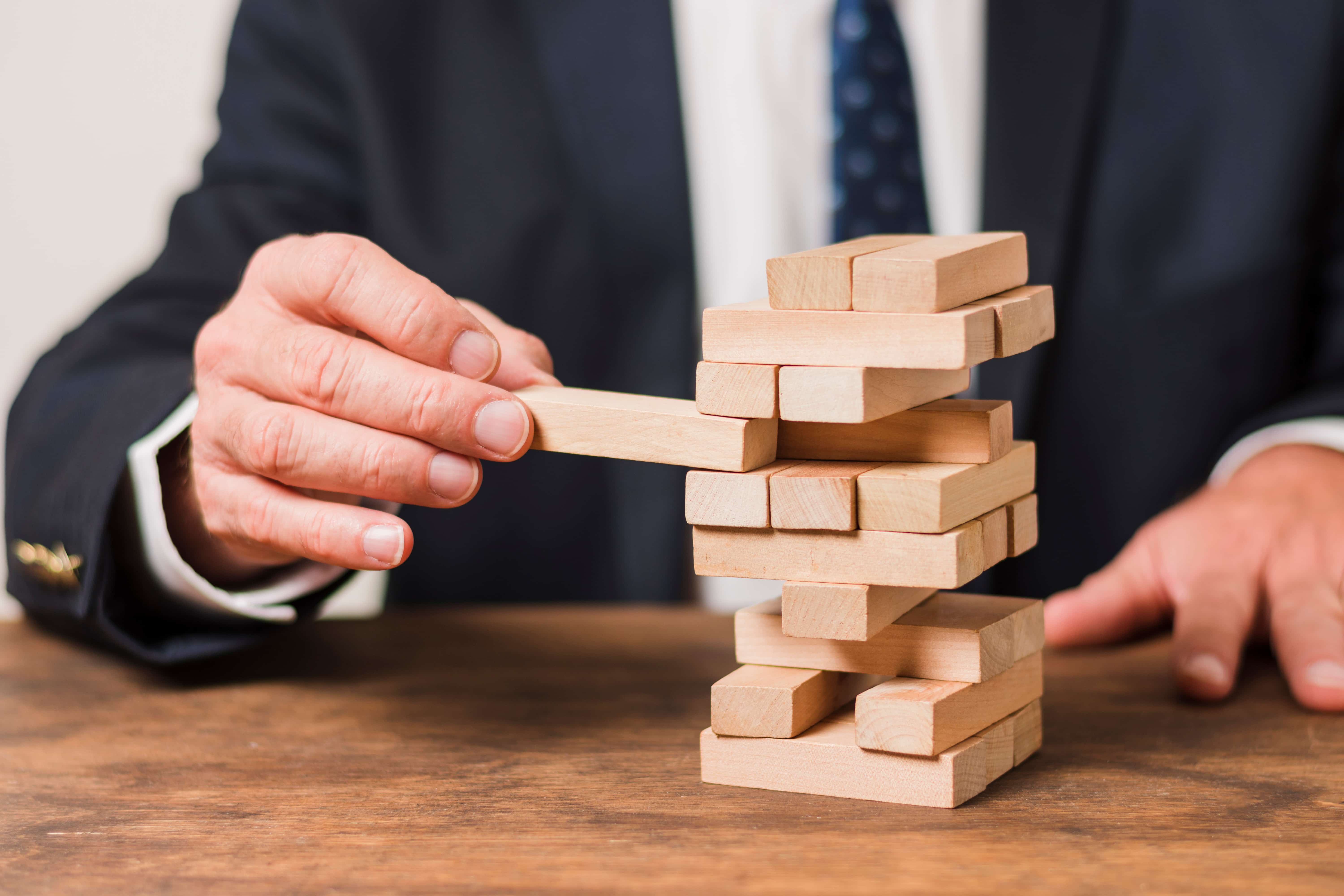 Homem de negócios jogando Jenga - Jerone Toledo Frente